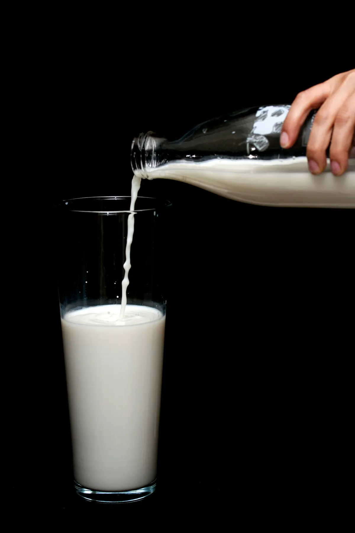Leche fresca vertida de una botella de vidrio